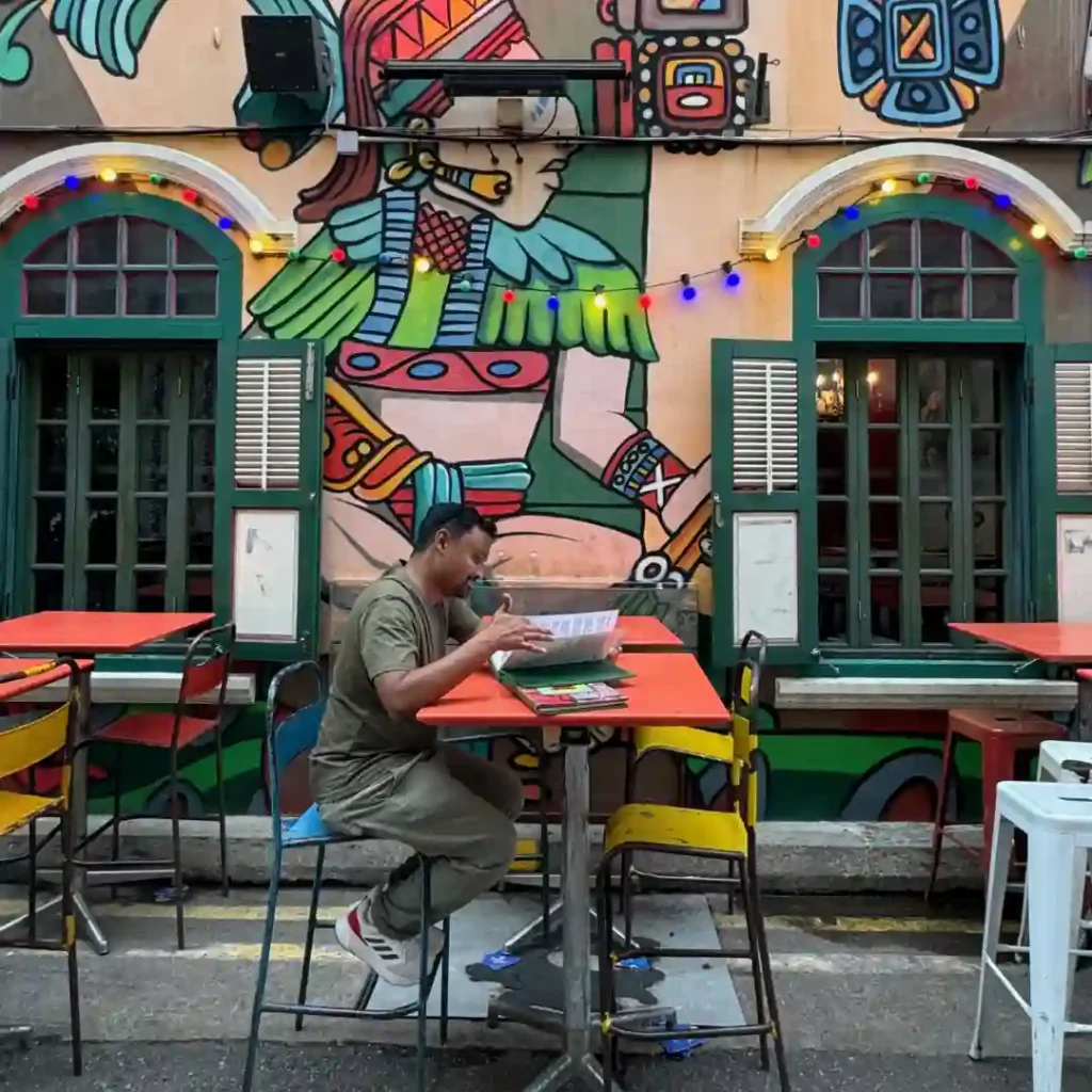 Man reading a menu alone at a vibrant café, reflecting self-discovery, quiet moments, and the beauty of solo journeys later in life