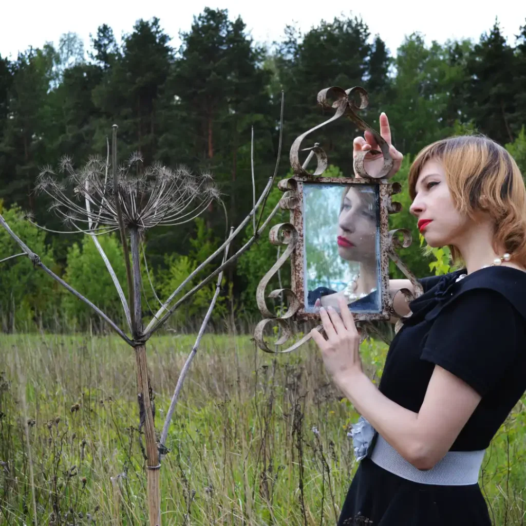 Woman looking at her reflection in an outdoor mirror, symbolising self-doubt and feeling left behind as a late bloomer